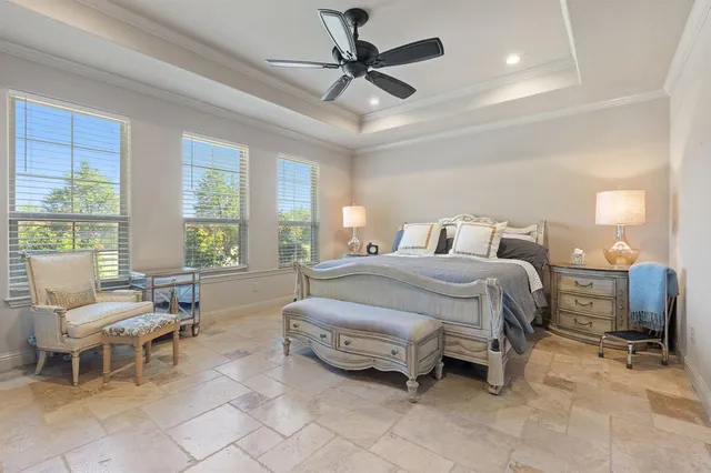 a bedroom with a bed and large windows