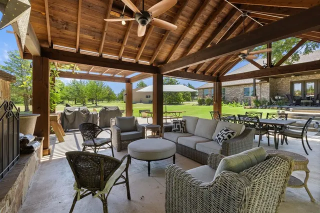 a living room with patio furniture and a garden