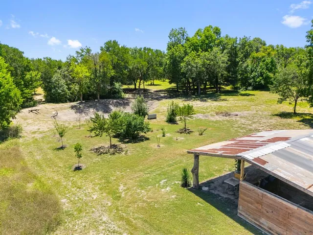 a view of a swimming pool with a lawn chairs under an umbrella