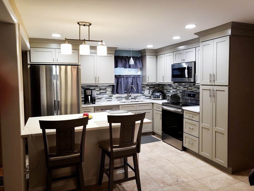 246 Lamont Street Springfield, MA 01119 - Photo 5 of 23 a kitchen with stainless steel appliances a dining table chairs refrigerator and stove