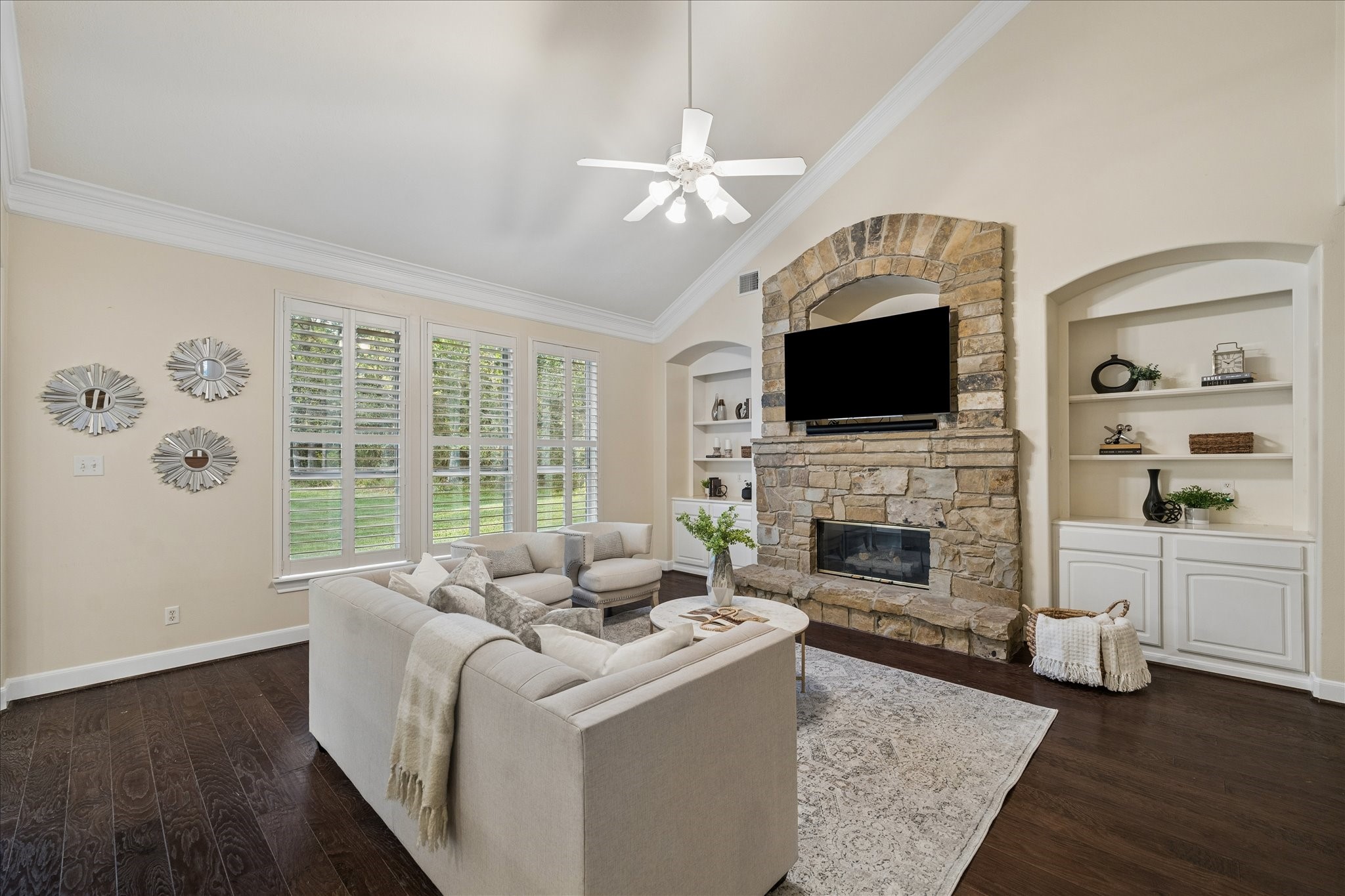 14530 Millhouse Road Pinehurst, TX 77362 - Photo 12 of 46 Another view of the living room centered around a stone fireplace, featuring built-in cabinetry and warm wood floors.