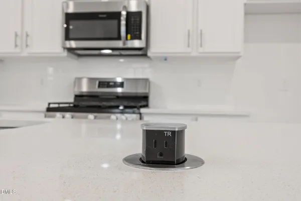 a kitchen with stainless steel appliances granite countertop a sink a stove and a wooden floors