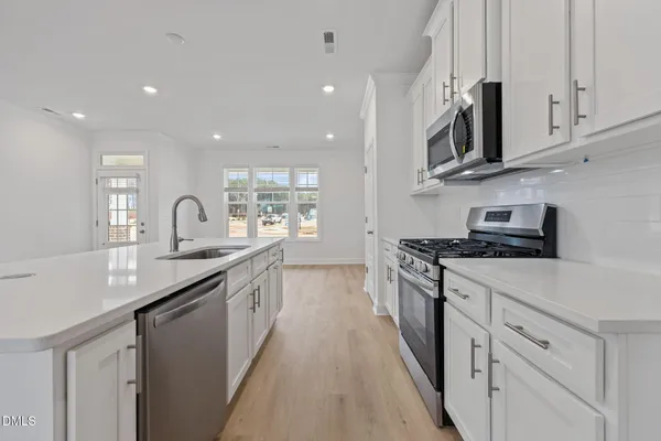 a view of kitchen with cabinets microwave and stove