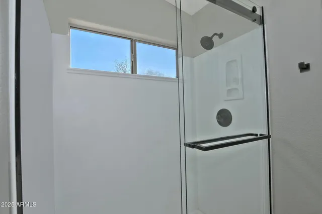a bathroom with a shower and mirror