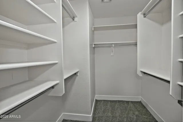 a view of walk in closet with empty racks