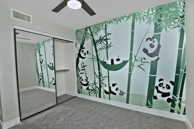 an empty room with a window and a fan