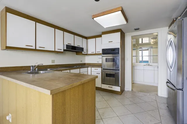 a kitchen with stainless steel appliances granite countertop a sink a stove top oven a counter space and cabinets
