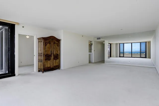 a view of an empty room with a fireplace and large window