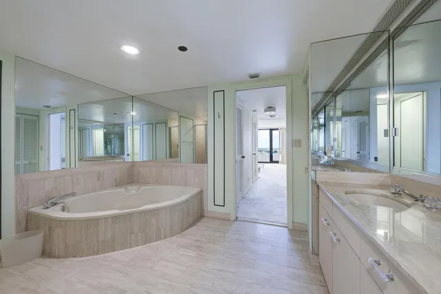 a spacious bathroom with a tub sink shower and mirror