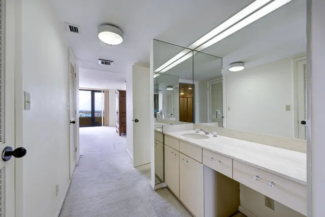 a spacious bathroom with a shower sink and mirror