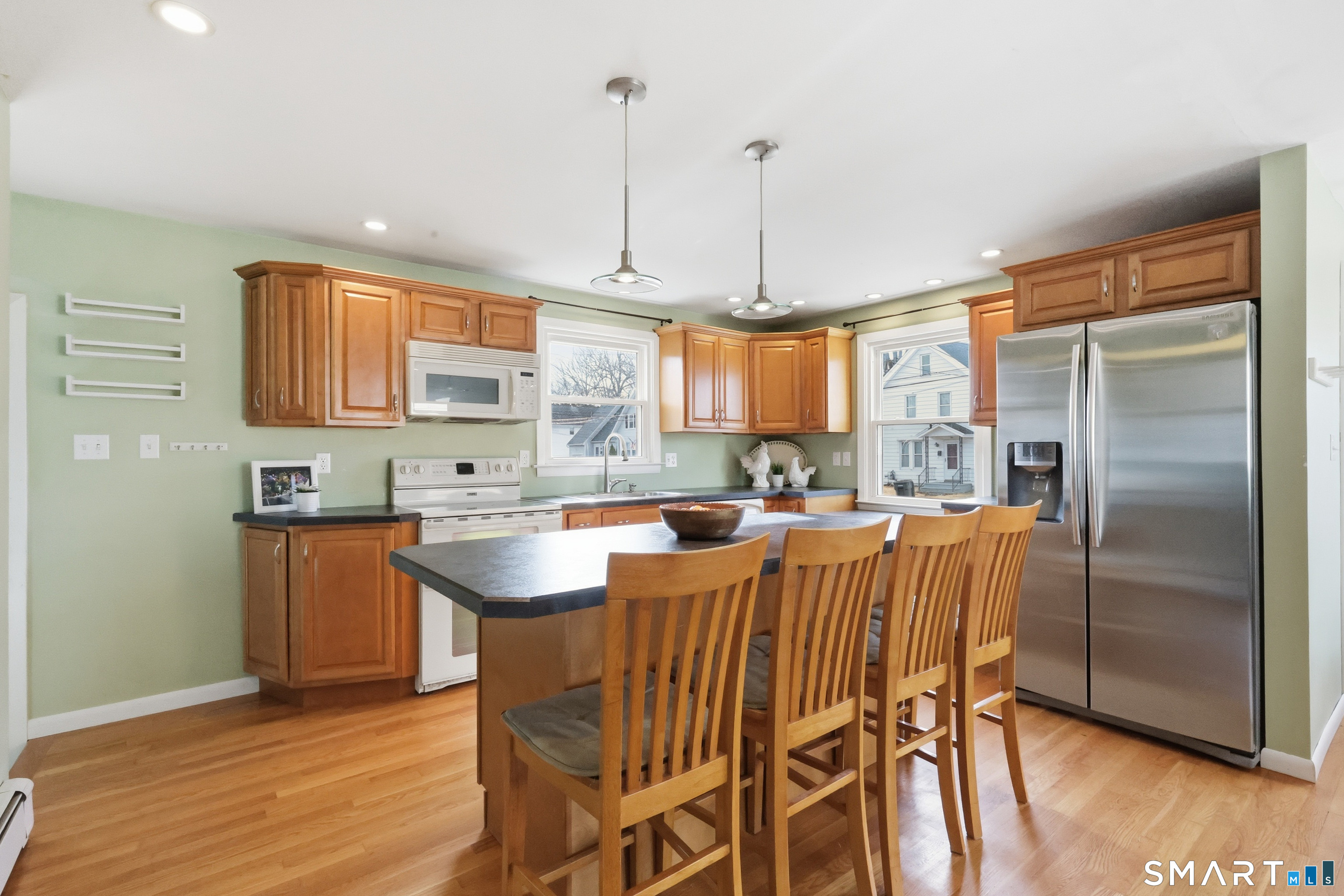 89 North Hoadley Street Naugatuck, CT 06770 - Photo 8 of 28 a kitchen with stainless steel appliances granite countertop a refrigerator a stove a sink dishwasher with a dining table and chairs