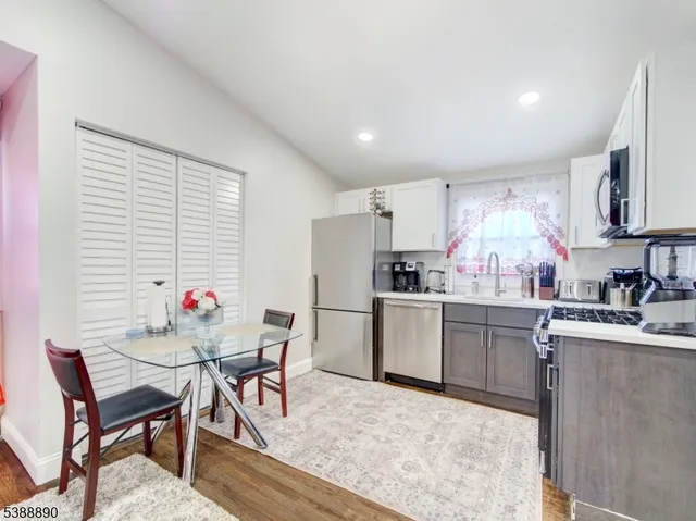 a kitchen with refrigerator and chairs