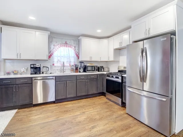 a kitchen with granite countertop a refrigerator stove top oven and sink