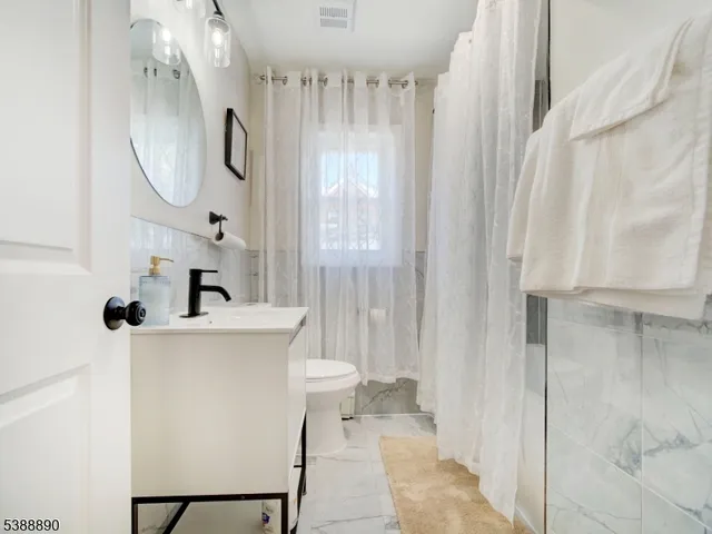 a bathroom with a sink a toilet and a mirror