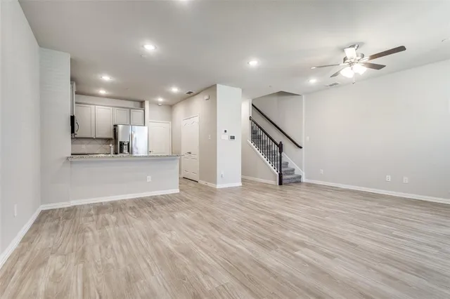 a view of a kitchen with wooden floor and an empty space