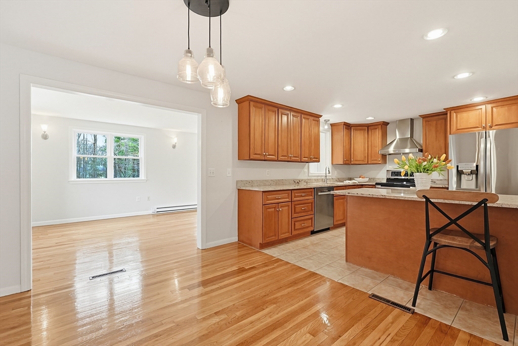 26 Beaver Brook Road Sharon, MA 02067 - Photo 13 of 42 a kitchen with stainless steel appliances granite countertop a refrigerator a stove a sink dishwasher and white cabinets with wooden floor
