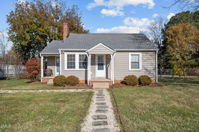 a front view of a house with a garden and yard