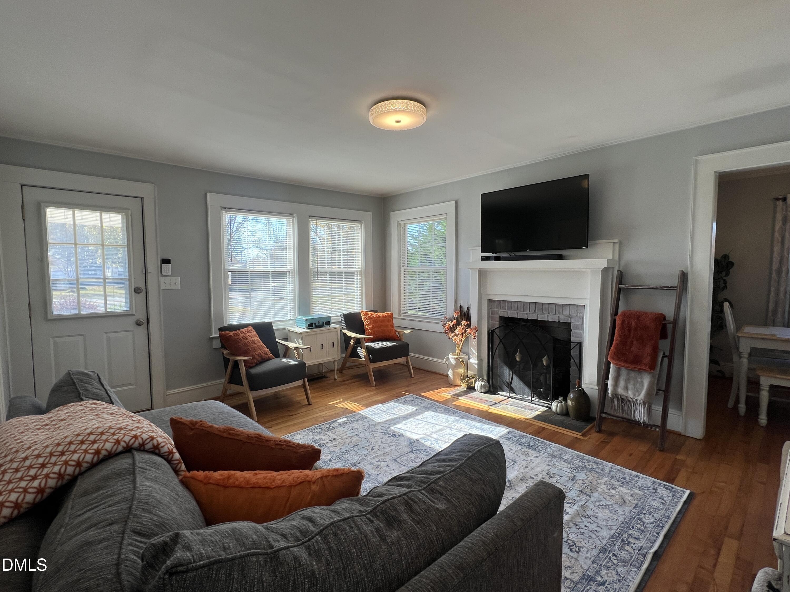 128 Moore Street Graham, NC 27253 - Photo 22 of 45 a living room with furniture a fireplace and a flat screen tv