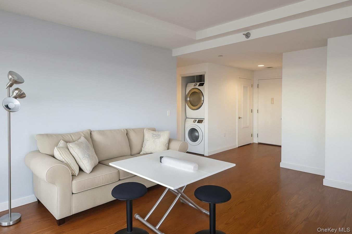 40-22 College Point Boulevard, Unit PH2K Queens, NY 11354 - Photo 6 of 14 a living room with a couch and a table with wooden floor