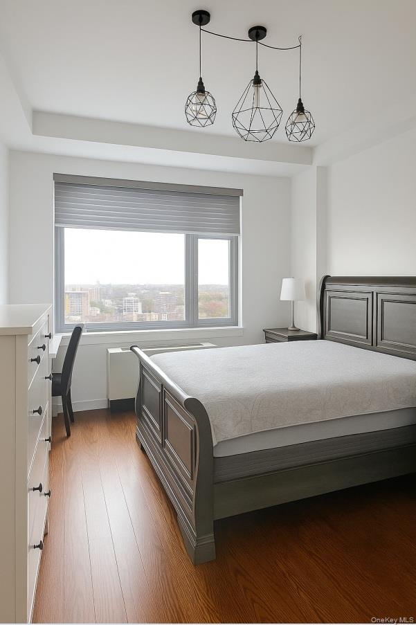 40-22 College Point Boulevard, Unit PH2K Queens, NY 11354 - Photo 7 of 14 a bedroom with a bed and a chandelier