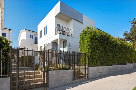 a view of a building with a small yard and wooden fence