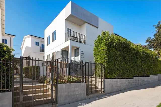 a view of a building with a small yard and wooden fence