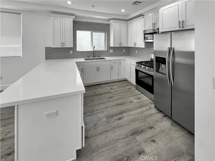 a kitchen with stainless steel appliances a refrigerator sink and cabinets