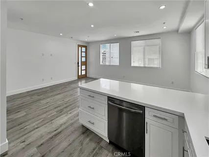 a room with hard wood floors and white cabinets