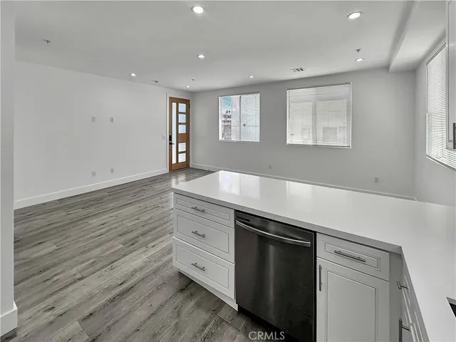 a room with hard wood floors and white cabinets