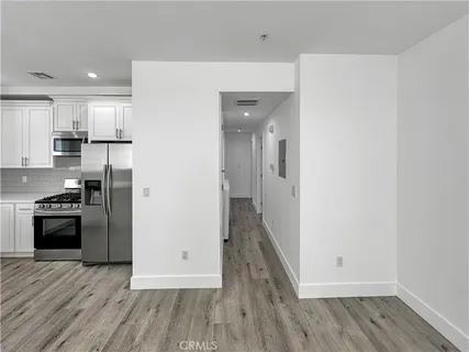 a kitchen with a refrigerator and a stove top oven