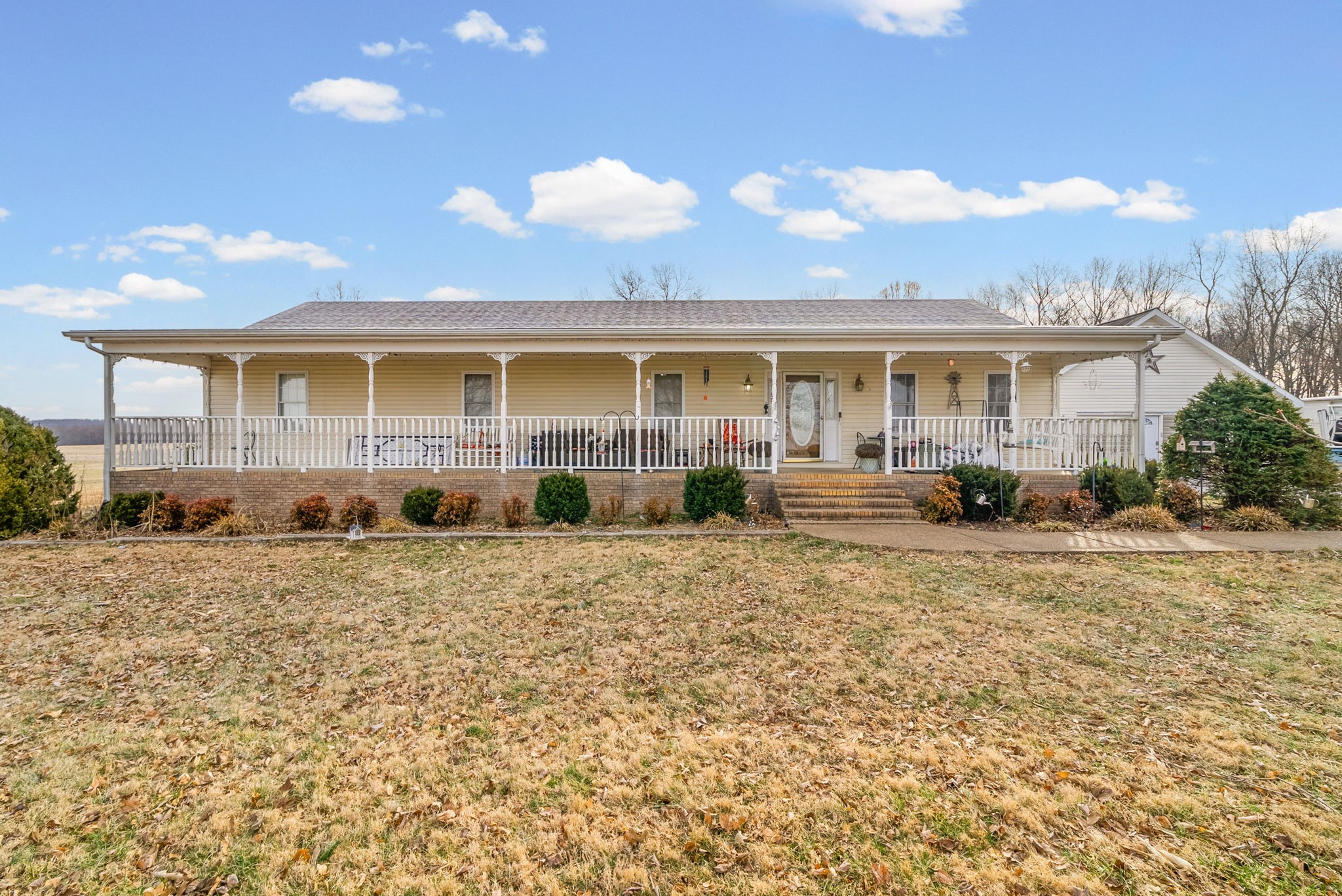 a front view of a house with a yard and potted plants