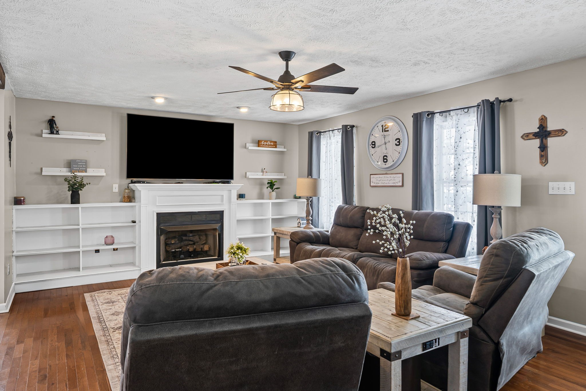 a living room with furniture a fireplace and a flat screen tv