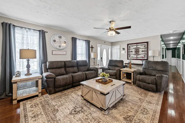 a living room with furniture a ceiling fan and a window
