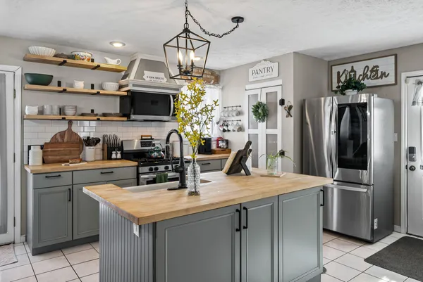 a kitchen with stainless steel appliances a sink a refrigerator a stove and cabinets