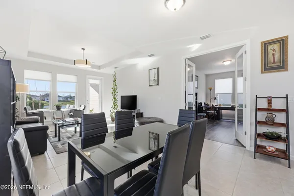 a bedroom with a bed next to a large window with wooden floor