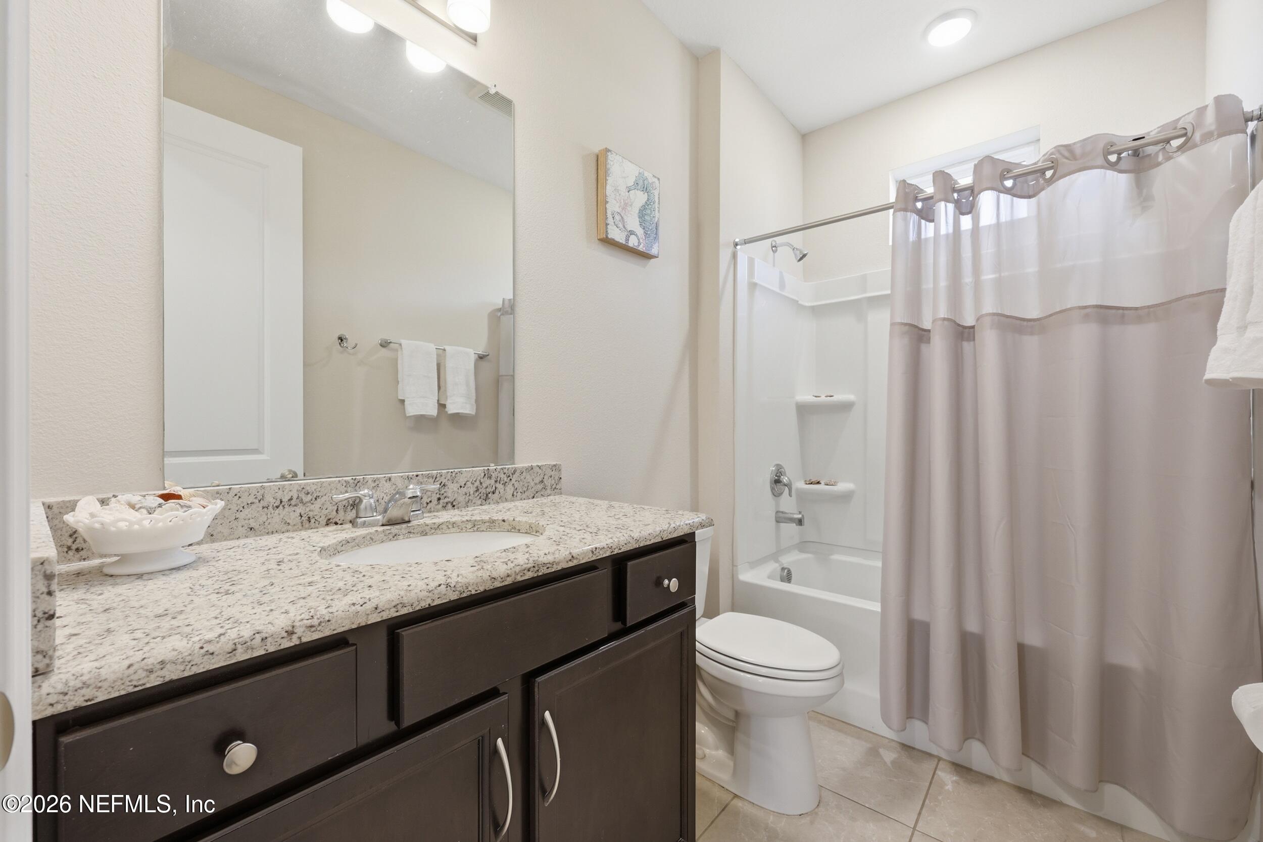 996 Rustic Mill Drive St. Augustine, FL 32092 - Photo 25 of 53 a bathroom with a granite countertop sink toilet a large mirror a shower and a bathroom