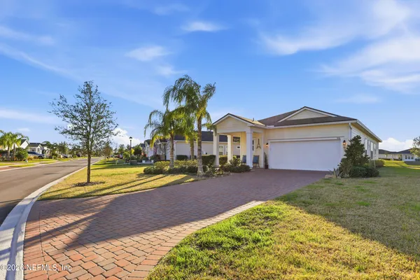 a view of a house with a yard and potted plants