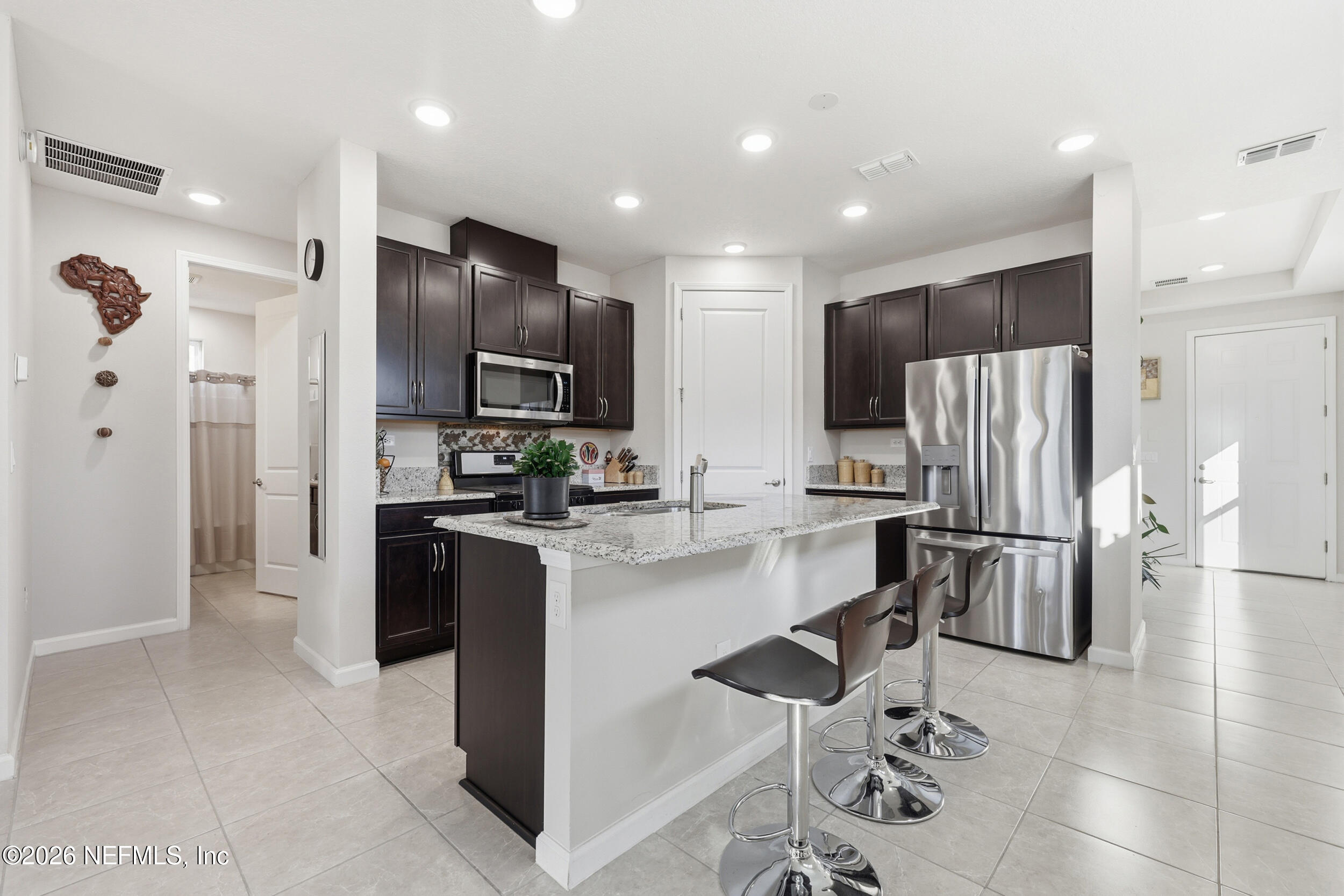 996 Rustic Mill Drive St. Augustine, FL 32092 - Photo 6 of 53 a kitchen with a refrigerator a sink and chairs