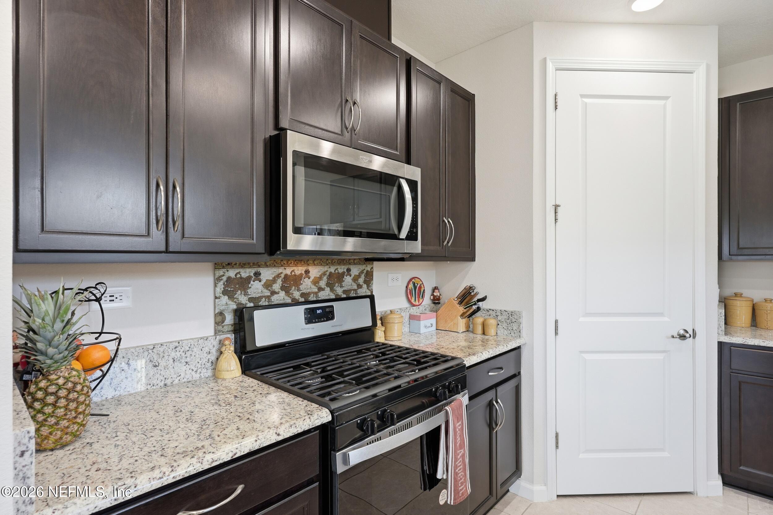 996 Rustic Mill Drive St. Augustine, FL 32092 - Photo 8 of 53 a kitchen with granite countertop stainless steel appliances a sink stove top oven and microwave