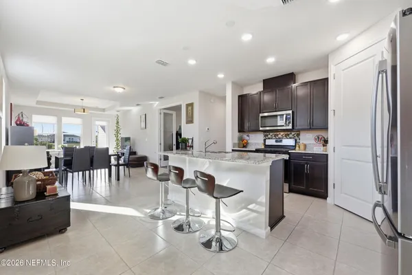 a kitchen with a refrigerator a sink and chairs