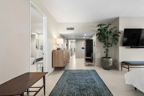 a spacious bedroom with a bed a couch and a potted plant