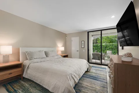 a bedroom with a bed and a view of balcony