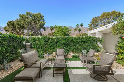 a view of a patio with table and chairs and potted plants
