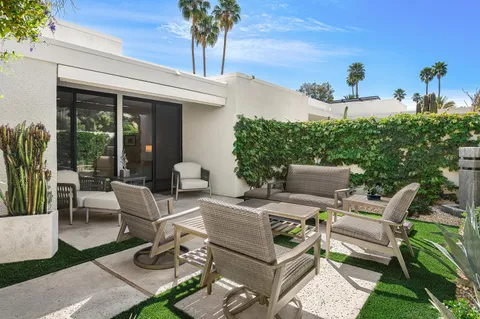 a view of a patio with couches table and chairs and potted plants