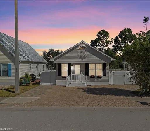 a front view of a house with yard and parking