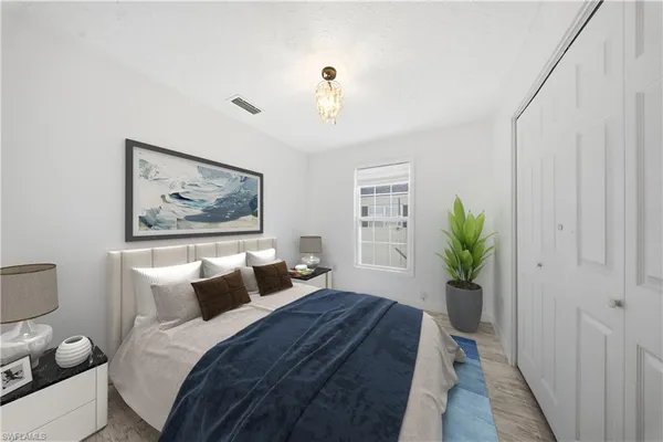 a bedroom with bed and painting on the wall