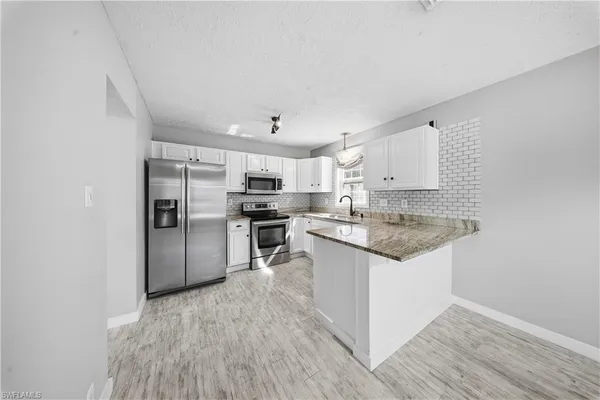 a kitchen with granite countertop a refrigerator and a sink