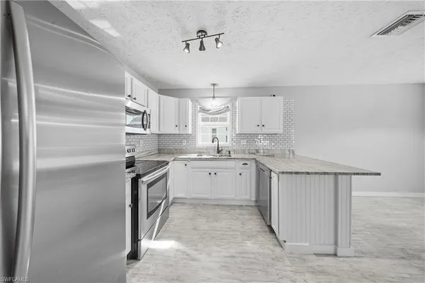 a kitchen with white cabinets and white appliances