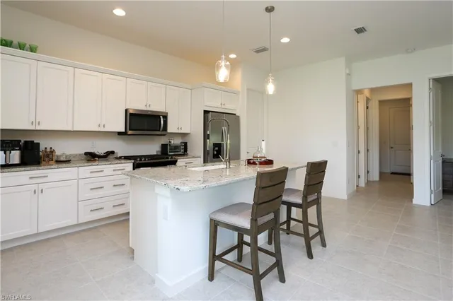 a kitchen with a sink white cabinets and stainless steel appliances