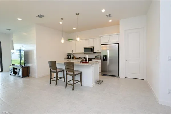 a kitchen with refrigerator and chairs